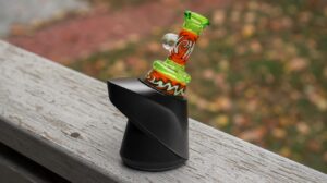 Roots Glass wig wag Puffco top mounted on a real Puffco Peak base on a porch rail, a puffco wholesale display piece